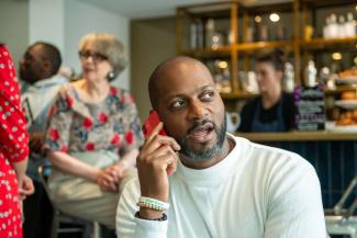 A man in a coffee shop talking into a mobile phone