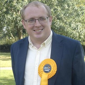 A man wearing a parliamentary rosette