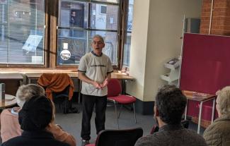 A man talking in front of an audience.