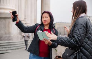 A woman giving directions to another woman in the street