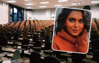 A woman smiling, with an empty lecture theatre as a backdrop