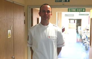 A uniformed man standing in a hospital corridor