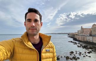 A man by the coast taking a selfie