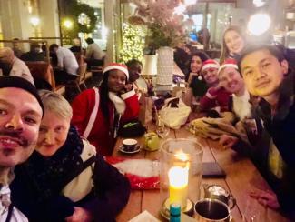 A group of people around a restaurant table, smiling at the camera