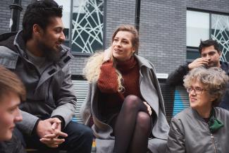 Five people sitting and chatting