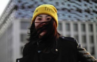 A woman looking at the camera. Her hair covering most of her face.