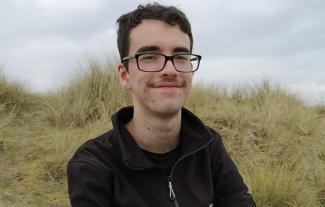 A man in an outdoor setting, smiling for the camera