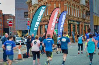 People on a sponsored run, with spectators cheering them on