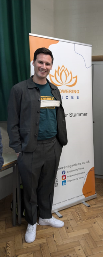 A man standing next to a promotional banner