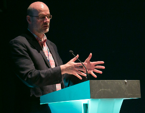 A man speaking at a lecturn