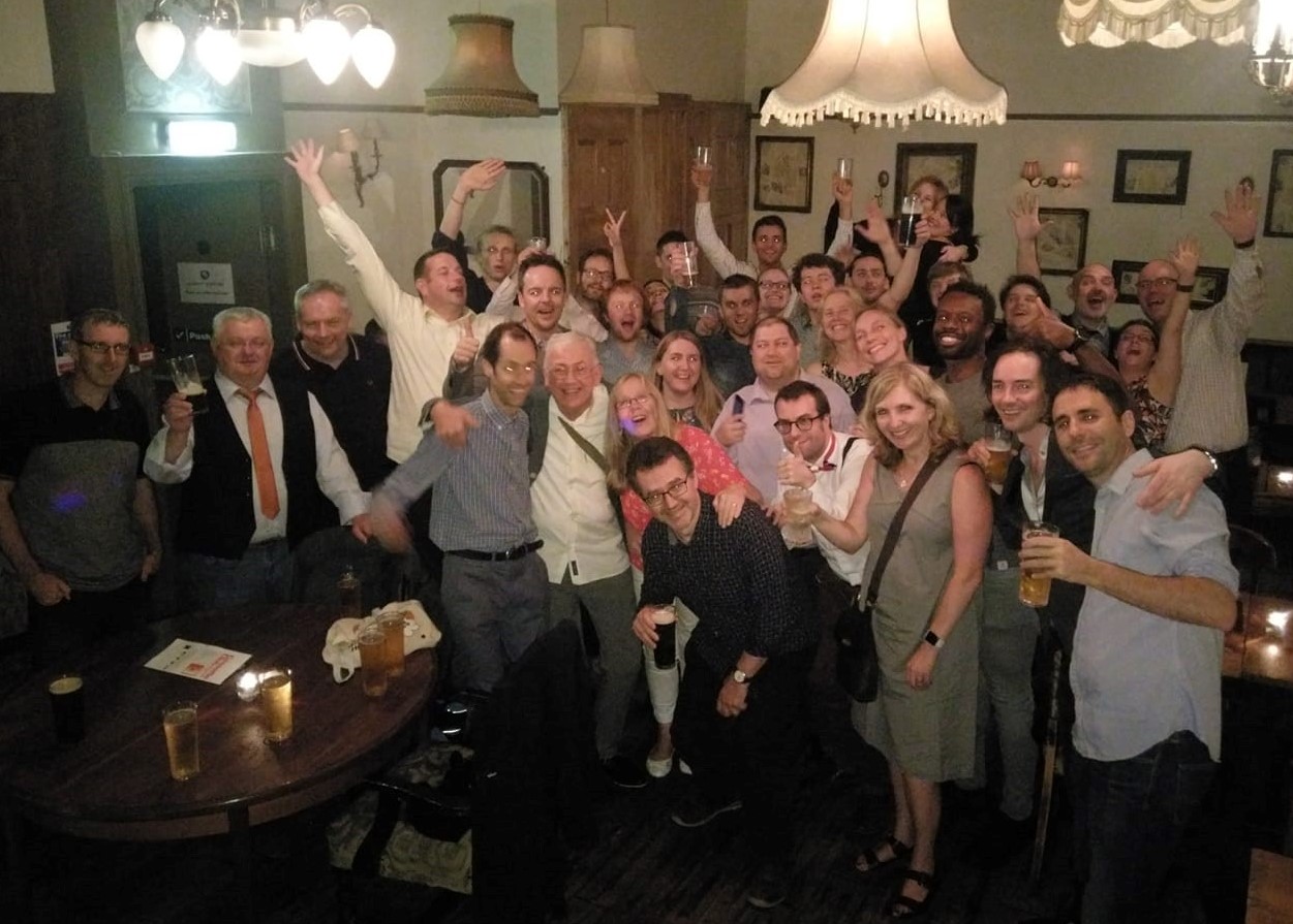 A group of people in a pub looking at the camera